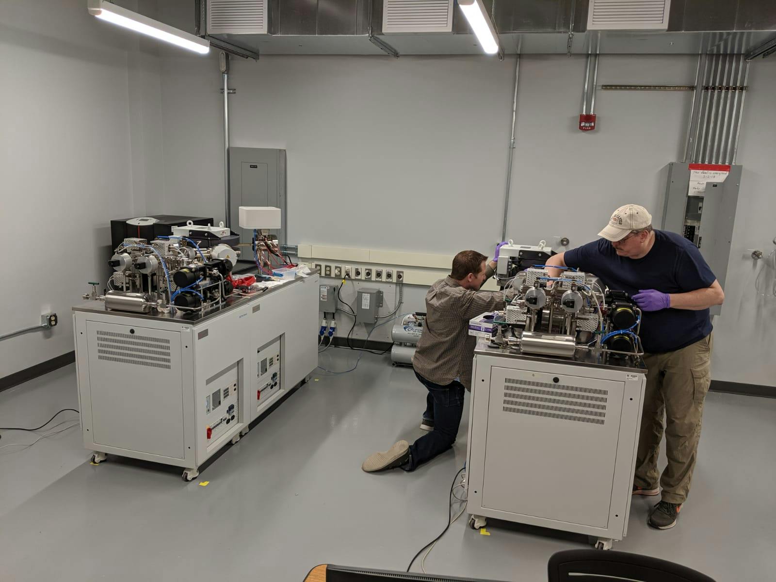<p>Taylor from ThermoScientific and Dan Miggins setting up the machines after they were transferred from the smaller room.</p>